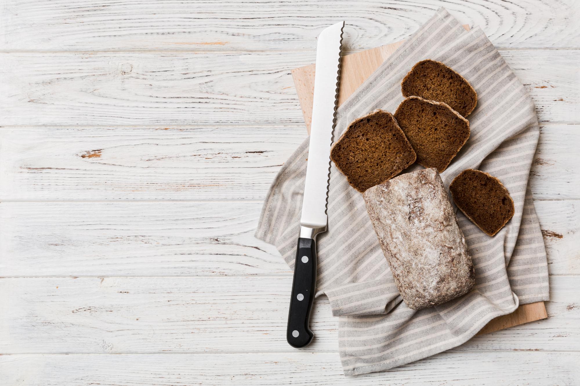 Wooden board with baked loaf and knife